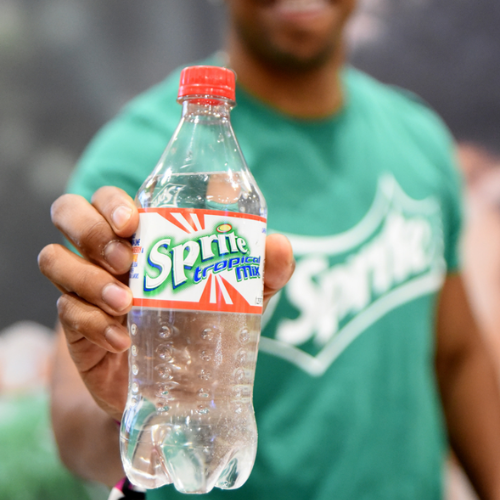 A man holding a bottle of sprite tropical mix